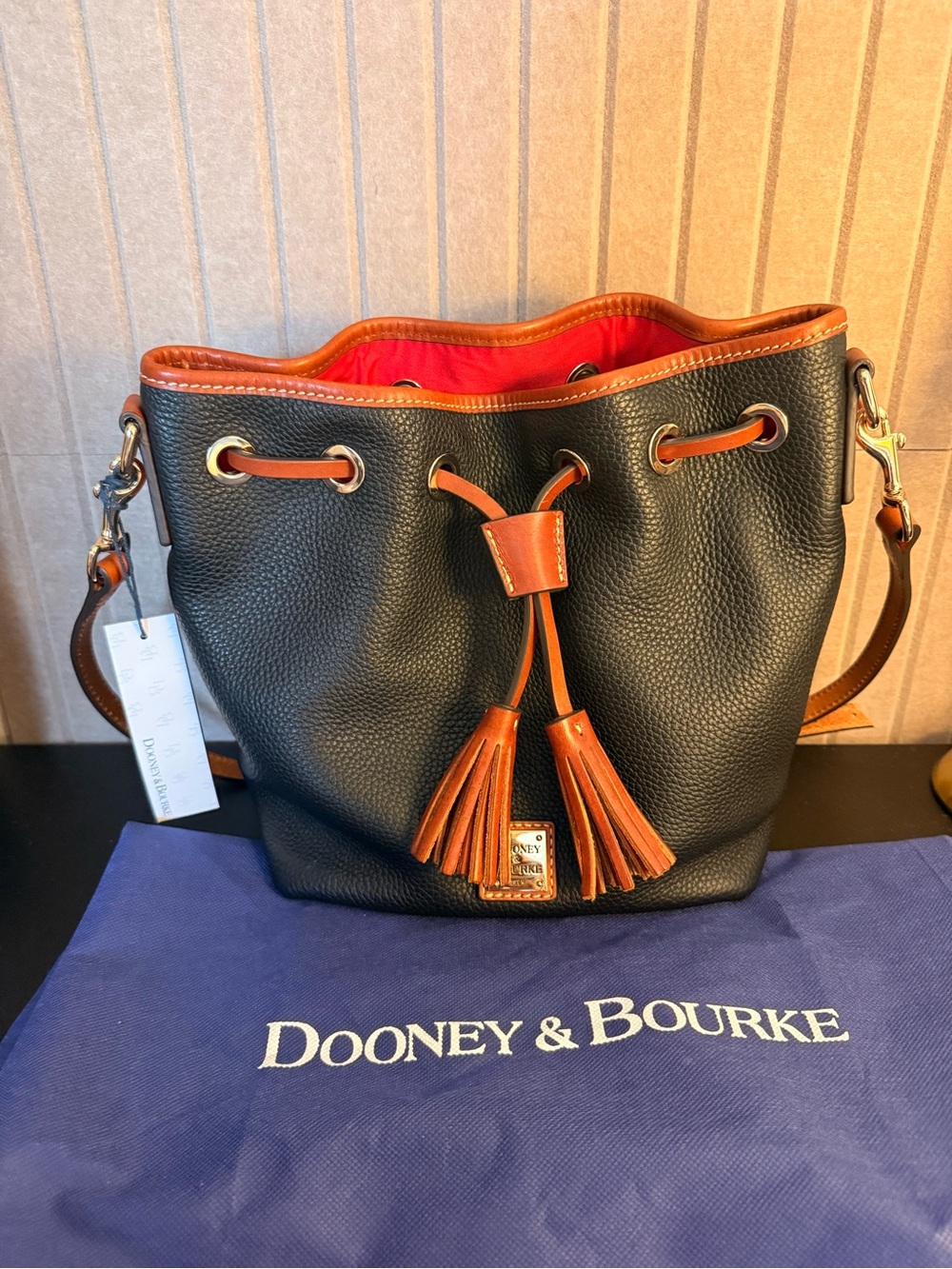 Dooney & Bourke Black Pebble Leather Bucket Bag with Brown Trim and Red Interior